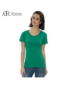 A kelly green coloured ring spun round neck ladies tee veing worn by a woman with medium brown hair stood in front of a grey brick wall