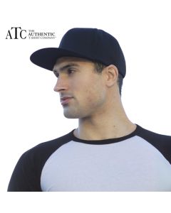 A man wearing a white and black baseball t-shirt and a dark coloured flexfit snapback cap