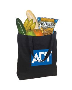 A large, black sturdy cotton canvas tote filled with food. The print on the front is white and blue.
