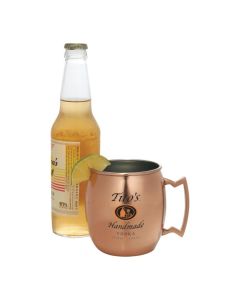 A 16oz copper and stainless steel moscow mule mug with black and orange logo in front of a bottle of beer