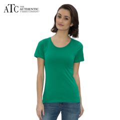 A kelly green coloured ring spun round neck ladies tee veing worn by a woman with medium brown hair stood in front of a grey brick wall