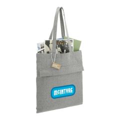 A branded recycled cotton tote filled with paperwork. The custom print on the front is blue, green and white.