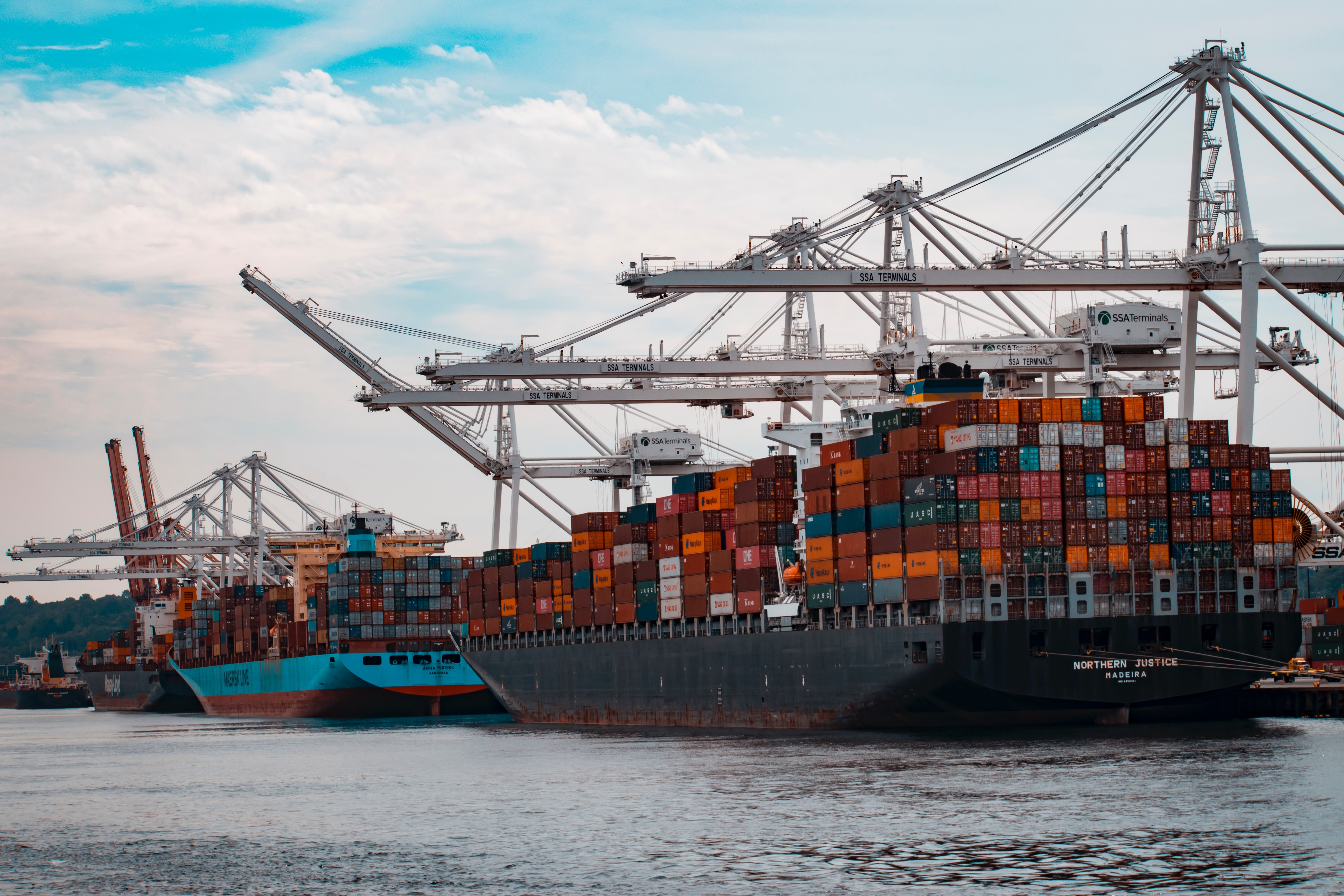 Group of freight boats docked at port to unload offshore goods