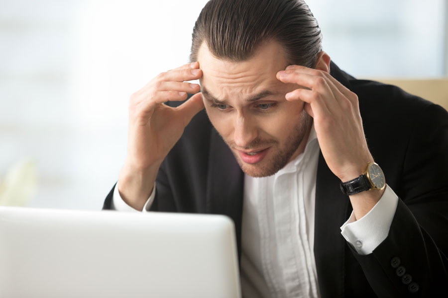 Frustrated man looking at laptop screen