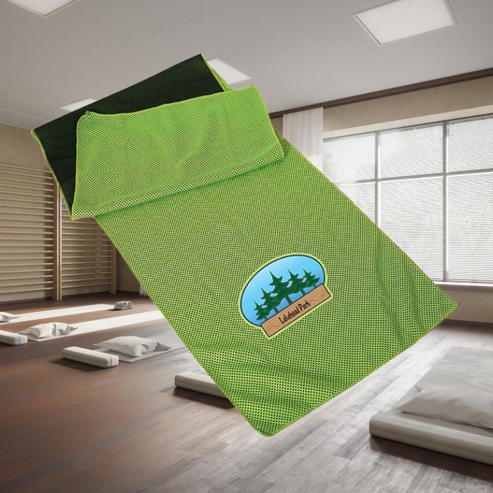 A green cooling towel in front of a yoga studio background.