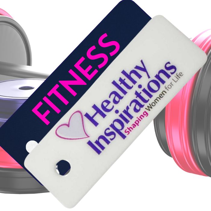 Two plastic membership cards, side by side. The closest card is black with purple and pink text. The furthest card is purple with pink text. Both cards are in front of a set of black and pink gym weights.