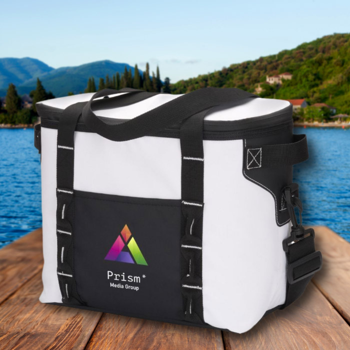 An angled view of a white can cooler sitting at the edge of a dock at beautiful lake on a clear day, with mountains in the background.