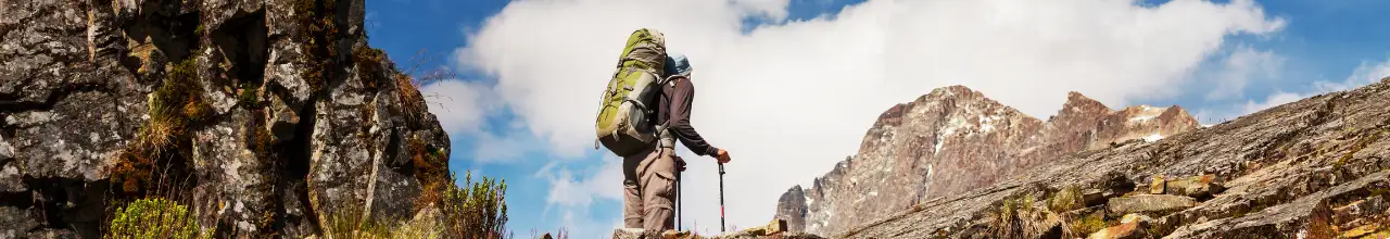 A man hiking in the wilderness of Canada while wearing a custom hiking backpack and vintage hiking gear.