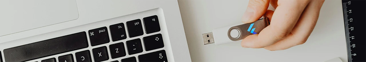 A man plugs a custom printed USB flash drive into his laptop, ready for a day of working from home in Alberta.